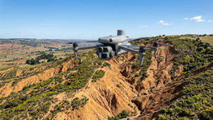 Drone realizando mapeamento aerofotogramétrico sobre área degradada pela Agrega Verde. A tecnologia permite gerar modelos digitais de terreno em 3D (MDT/MDS), identificar focos de erosão com precisão centimétrica e planejar projetos de revegetação com máxima eficiência técnica e operacional.